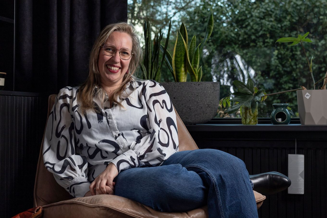Maxime Chloë de Vos in een fauteuil tussen de kamerplanten