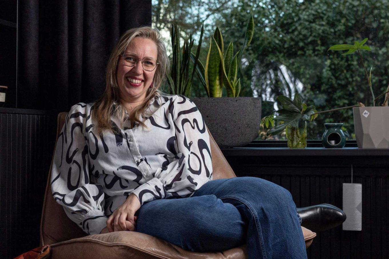 Maxime Chloë de Vos in een fauteuil tussen de kamerplanten