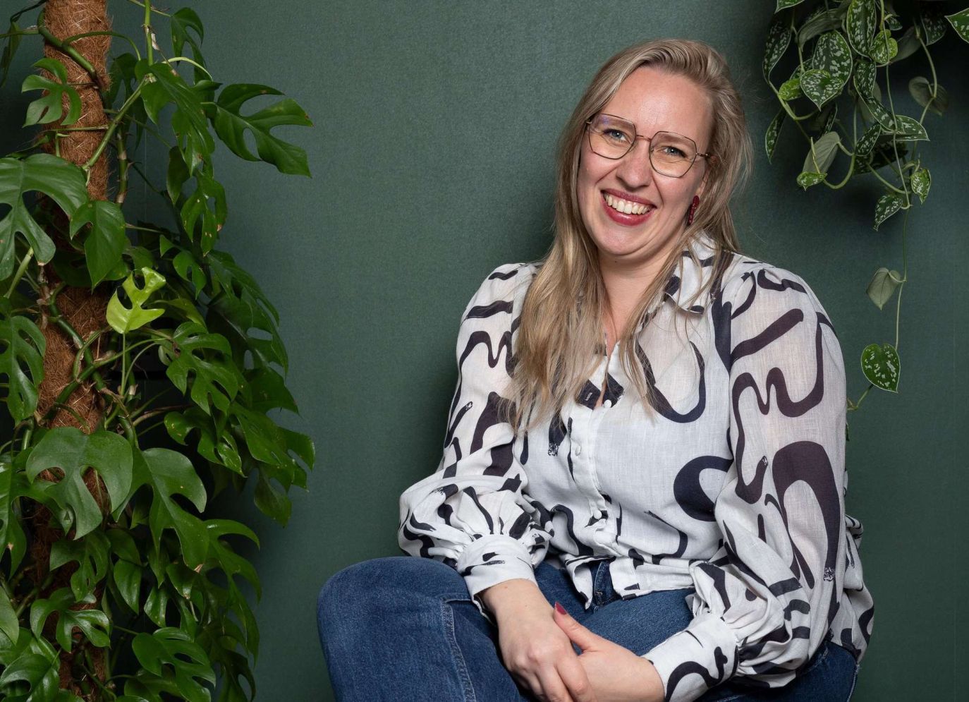 Maxime Chloë de Vos zit ontspannen tussen de planten in haar werkkamer